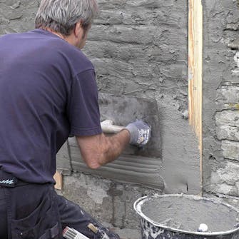 Mur med ødelagt puss og løse fuger: Dra mørtel på veggen mellom de to lirene Mur med ødelagt puss og løse fuger: Dra mørtel på veggen mellom de to lirene